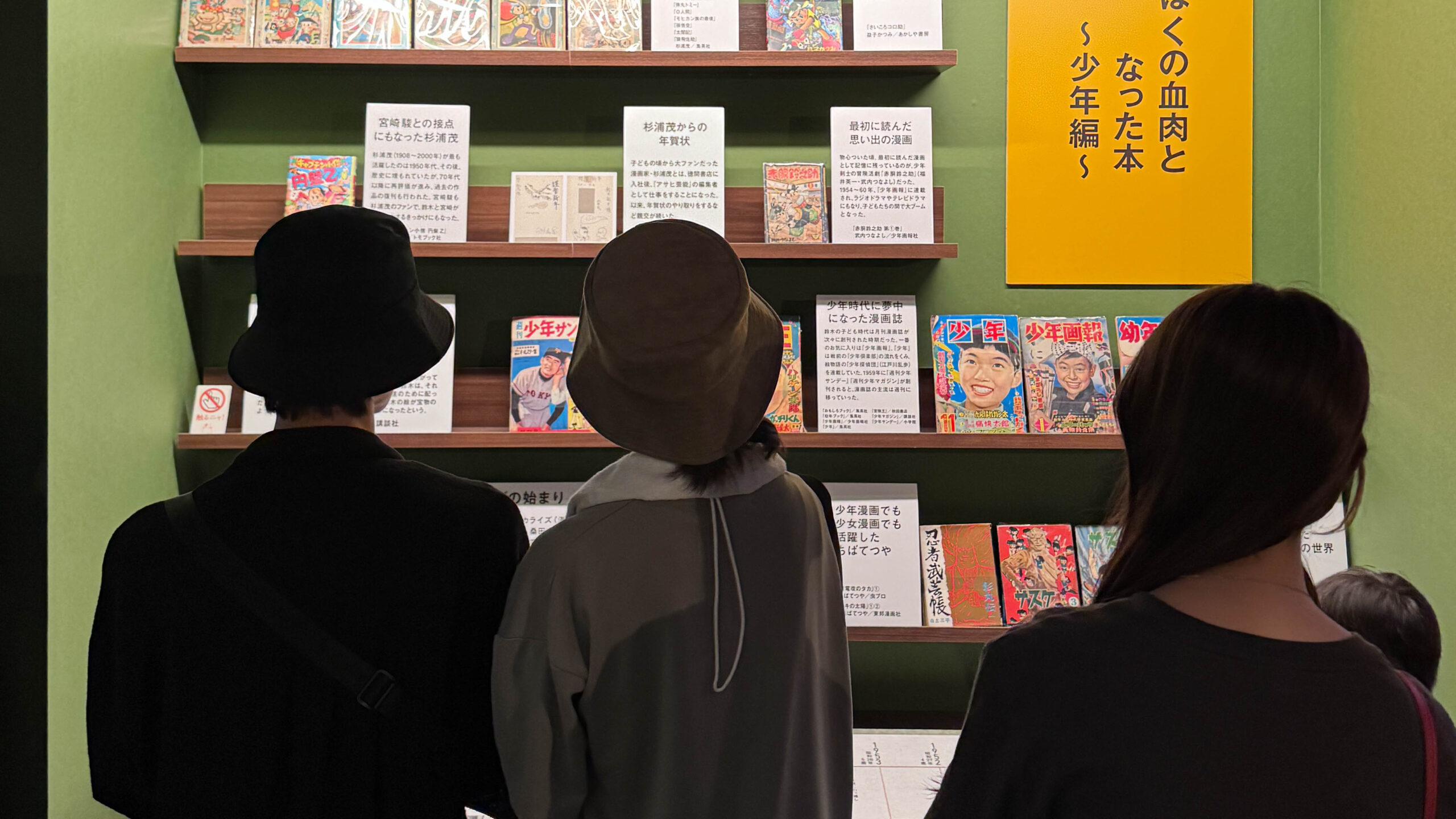 ผู้เข้าชมกำลังดูหนังสือและนิตยสารหายากที่จัดแสดงในงานนิทรรศการ Studio Ghibli